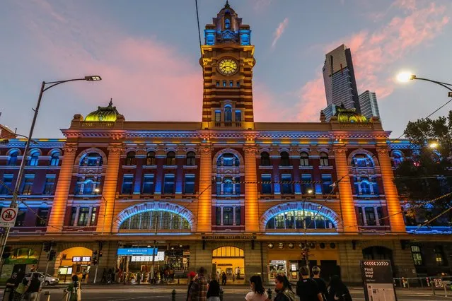 A general view of Flinders Street Station as it is lit in yellow and blue in Melbourne on February 24, 2022, as public buildings lit up in the national colours of Ukraine as a show of support. (Photo by Asanka Brendon Ratnayake/AFP Photo)