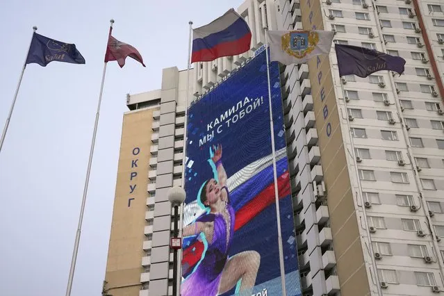 A huge electronic billboard shows a photo of Kamila Valieva with words “Kamila, we are with you” on the building of the Salut hotel in Moscow, Russia, Monday, February 14, 2022. Russian teenager Kamila Valieva has been cleared to compete in the women's figure skating competition at the Winter Olympics despite failing a pre-Games drug test. (Photo by Alexander Zemlianichenko/AP Photo)