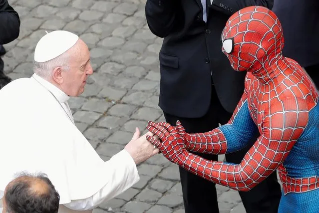 Pope Francis receives a Spider-Man mask from a person dressed as Spider-Man after the general audience, amid the coronavirus disease (COVID-19) pandemic, at the Vatican, June 23, 2021. (Photo by Remo Casilli/Reuters)