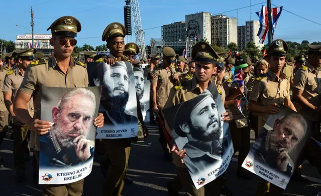 People display images of Cuban former president Fidel Castro during the May Day parade at Revolution Square in Havana, on May 1, 2016. (Photo by Jorge Beltran/AFP Photo)