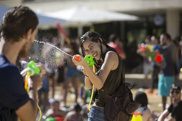 A participant uses a water gun during a water fight in Tel Aviv, July 10, 2015. (Photo by Baz Ratner/Reuters)