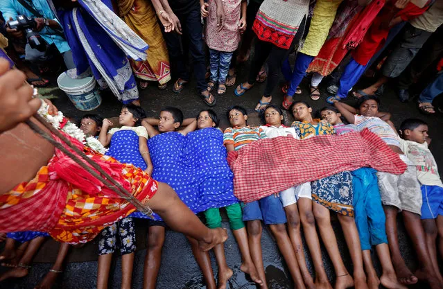 A Hindu holy man touches children with his foot as part of a ritual to bless them during a religious procession to mark the Gajan festival in Kolkata, April 13, 2017. (Photo by Rupak De Chowdhuri/Reuters)