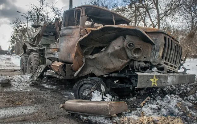 A damaged military vehicle sits in Kharkiv, Ukraine, Wednesday, March 16, 2022. (Photo by Andrew Marienko/AP Photo)