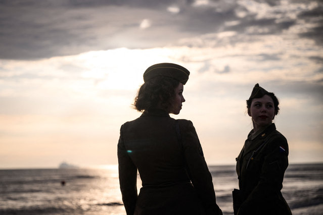 Bystanders in WWII-era military attire look on prior to a joint US and French amphibious landing operation showcase, on June 4, 2024, at Omaha beach in Saint-Laurent-sur-Mer, northwestern France, ahead of the “D-Day” commemorations marking the 80th anniversary of the World War II Allied landings in Normandy. (Photo by Loic Venance/AFP Photo)