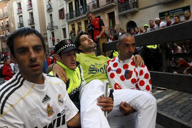 An injured unidentified runner is taken away following the seventh running of the bulls of the San Fermin festival in Pamplona, northern Spain, July 13, 2015. Two runners were gored in the run that lasted two minutes and twelve seconds, according to local media. (Photo by Joseba Etxaburu/Reuters)