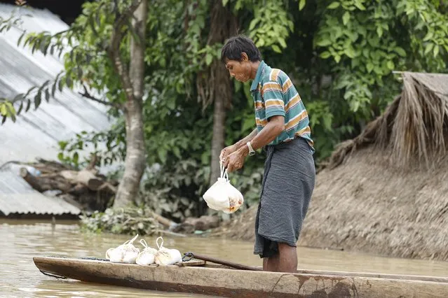 A man holds food collected from local donors at a village in Kawlin township, Sagaing division, Myanmar, July 21, 2015. (Photo by Soe Zeya Tun/Reuters)