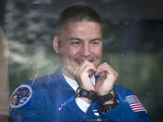 Kjell Lindgren of the U.S., a member of the International Space Station (ISS) crew, gestures to his family from a bus before departure for a final pre-launch preparation at the Baikonur cosmodrome, Kazakhstan, July 22, 2015. (Photo by Shamil Zhumatov/Reuters)