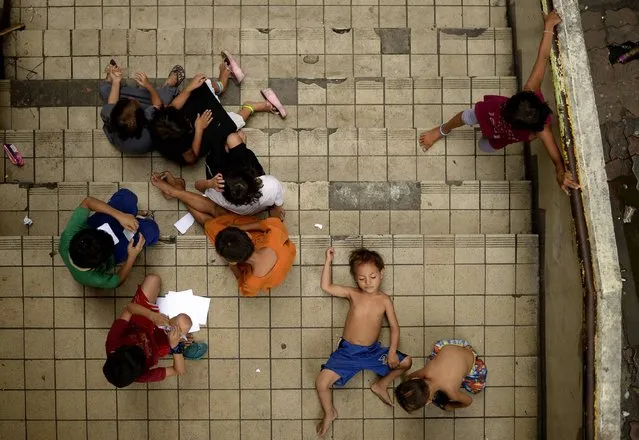 Homeless children play on a staircase at the Light Railway Train (LRT) Carriedo station in Manila on May 26, 2016. Incoming Philippine president Rodrigo Duterte pledged on May 26 to spread economic activity beyond the overpopulated capital of Manila, calling it a “dead” city overrun by shantytowns. (Photo by Noel Celis/AFP Photo)