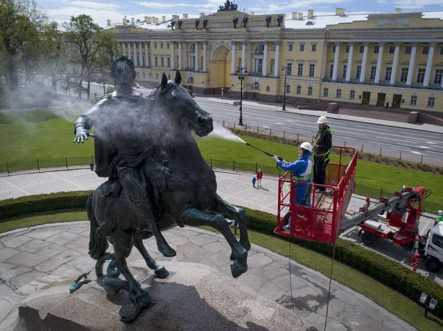 A worker washes a city landmarks, the equestrian statue of Peter the Great known as the Bronze Horseman by French sculptor Etienne Maurice Falconet, in St.Petersburg, Russia, Friday, May 26, 2017. (Photo by Dmitri Lovetsky/AP Photo)