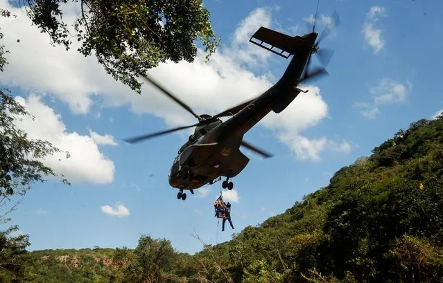 A member of a search and rescue team airlifts a body from the Mzinyathi River after heavy rains caused flooding near Durban, South Africa on April 19, 2022. (Photo by Rogan Ward/Reuters)