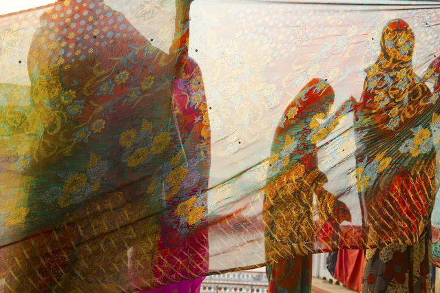 “Drying saris near the Ganges river”. A group of women dry their saris in the sun after they have been washed in the Ganges river. Photo location: Varanasi, Uttar Pradesh, India. (Photo and caption by Nacho Calonge/National Geographic Photo Contest)