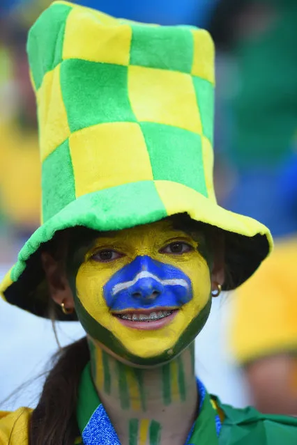 A Brazil fan with her face painted smiles before the 2014 FIFA World Cup Brazil Group A match between Brazil and Croatia at Arena de Sao Paulo on June 12, 2014 in Sao Paulo, Brazil. (Photo by Christopher Lee/Getty Images)