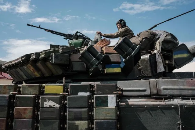 A Ukrainian soldier sits on a tank carryied by a transporter near Bakhmut, eastern Ukraine, on May 12, 2022, amid the Russian invasion of Ukraine. (Photo by Yasuyoshi Chiba/AFP Photo)