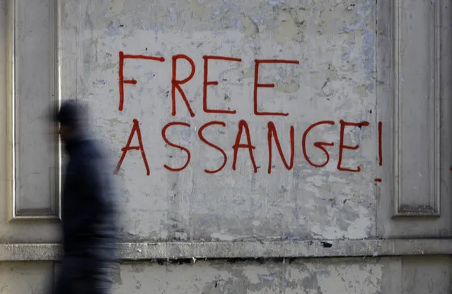 A pedestrian passes graffitti outside Westminster Magistrates Court in London, where Julian Assange is due to appear, Monday, January 13, 2020. Protesters will be insisting that Assange should not be extradited to the US for his reporting of the Iraq and Afghanistan war. They insist he will not face a fair trial in the United States where the charges against him could result in imprisonment for 175 years. Assange will be transported from Belmarsh high-security prison. (Photo by Kirsty Wigglesworth/AP Photo)