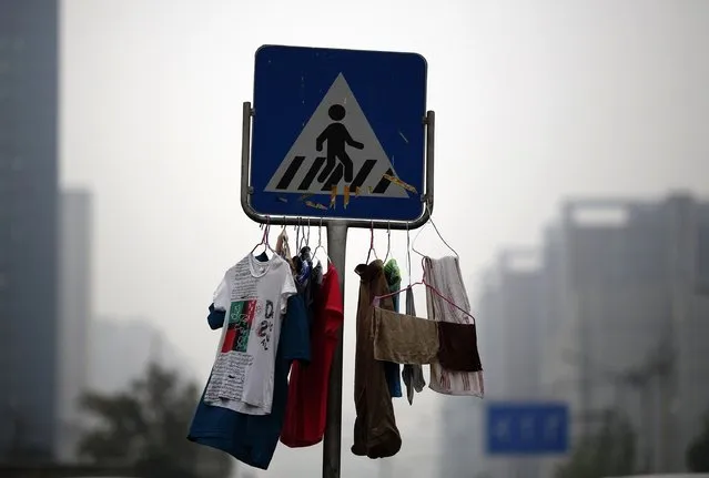 Laundry is hung on a traffic sign on a street in Beijing July 16, 2014. (Photo by Kim Kyung-Hoon/Reuters)