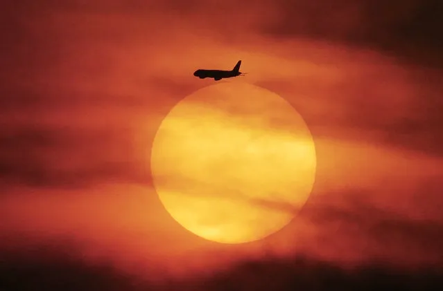 This photo taken on June 18, 2017 in Jakarta shows a plane in silohuette flying during a sunset. (Photo by Bay Ismoyo/AFP Photo)