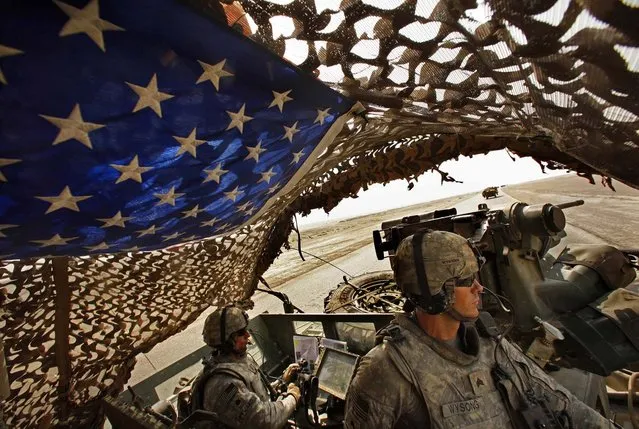 Lt. Col. Richard D. Heyward and Sgt. Nick Wysong keep watch as the Army's 4th Brigade, 2nd Infantry Division, the last formal U.S. military combat detachment to leave Iraq, crosses the southern desert lands of Iraq on August 17, 2010