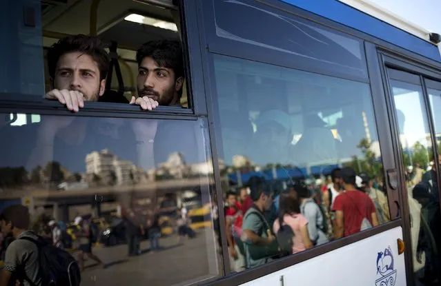 Syrian refugees look out from a bus window following their arrival onboard “Eleftherios Venizelos” passenger ship at the port of Piraeus near Athens, Greece, August 20, 2015. (Photo by Stoyan Nenov/Reuters)