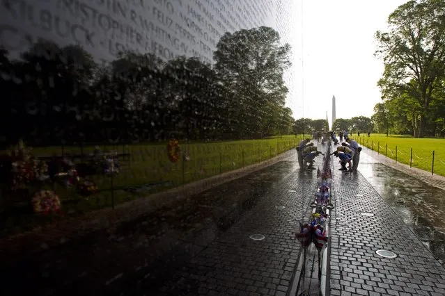 Visitor looks the names on the wall of the Vietnam Veterans Memorial in Washington DC, May 28, 2017. Motorcyclists are in Washington for the traditional annual Rolling Thunder ahead of Memorial Day, May 29. (Photo by Jose Luis Magana/AFP Photo)