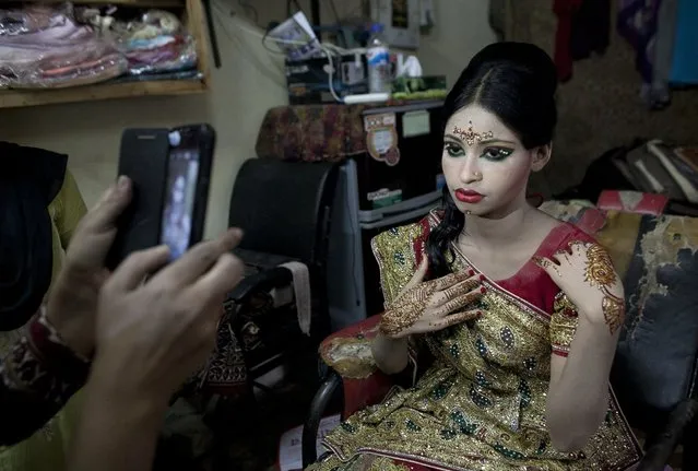 Nasoin Akhter, 15, poses for a photo at a beauty parlour on the day of her wedding to a 32-year-old man on August 20, 2015, in Manikganj, Bangladesh. (Photo by Allison Joyce/Getty Images)
