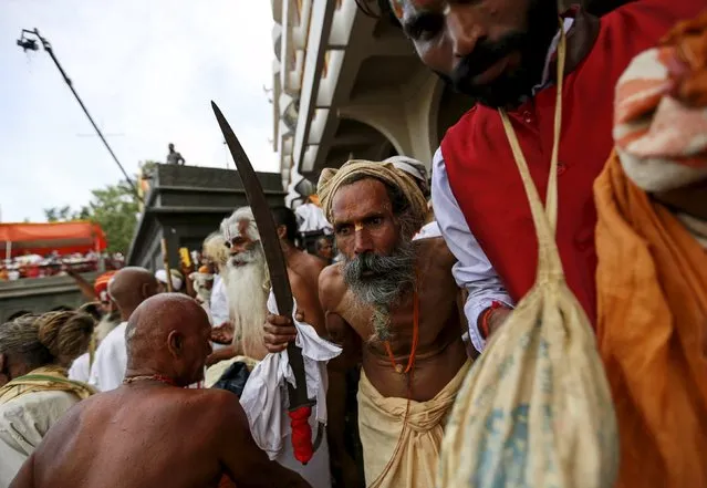 A Sadhu or Hindu holy man prepares to take a dip in the Godavari river during the first Shahi Snan (grand bath) at Kumbh Mela, or Pitcher Festival in Nashik, India, August 29, 2015. (Photo by Danish Siddiqui/Reuters)