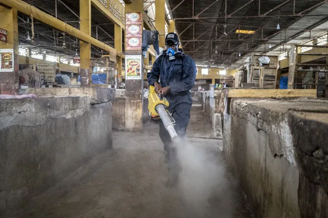 A municipal worker sprays disinfectant in the Grand Market of Dakar, Senegal in an attempt to halt the spread of the new coronavirus Monday, March 30, 2020. (Photo by Sylvain Cherkaoui/AP Photo)