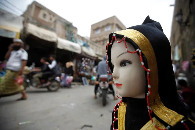 People walk past a mannequin on display at a stall at the old quarter of the city of Sanaa, Yemen, July 24, 2016. (Photo by Mohamed al-Sayaghi/Reuters)