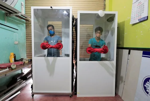 Workers check protective chambers with gloves attached made for hospitals at a workshop, during the curfew imposed by the government amid concerns over the spread of coronavirus disease (COVID-19), in Colombo, Sri Lanka, April 15, 2020. (Photo by Dinuka Liyanawatte/Reuters)