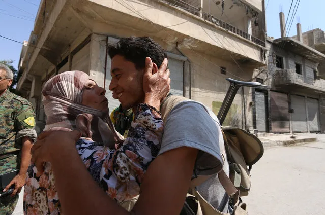 A woman approches a Syria Democratic Forces (SDF) fighter to kiss him after the fighters entered Manbij, in Aleppo Governorate, Syria, August 7, 2016. (Photo by Rodi Said/Reuters)