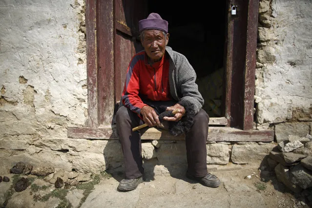 Khunjung Sherpa, 90, who earned 0.09 USD a day when he worked as a porter, sits outside his house in Namche, Solukhumbu District April 27, 2014. (Photo by Navesh Chitrakar/Reuters)