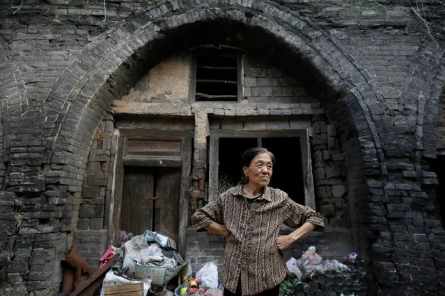 Li Yonghua, 65, stands in front of her damaged cave house in an area where land is sinking next to a coal mine, in Helin village of Xiaoyi, China's Shanxi province, August 2, 2016. (Photo by Jason Lee/Reuters)