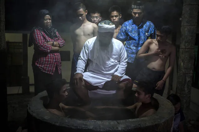 Ustad Ahmad Ischsan Maulana, the head of Nurul Ichsan Al Islami traditional rehabilitation centre, prays with recovering drug addicts who are immersed in a hot water herbal bath on September 16, 2017 in Purbalingga, Indonesia. Indonesian cleric Ahmad Ischsan Maulana started a traditional rehabilitation center 17 years ago in Purbalingga, Central Java, using traditional methods such as immersing his patients in boiling hot water between 10 to 30 minutes, herbal teas, prayer and counseling. Also known as “Kiai Suro Godog”, the Purbalingga center is one of the 160 across Indonesia that uses traditional methods and houses about 30 patients while Indonesia has become one of Southeast Asia’s biggest markets for narcotics over the past few years. Indonesian authorities recently expressed concerns over the street drugs entering the country and the adverse reactions caused by the abuse of a drug known as PCC. Based on local reports, at least one Indonesian schoolchild died last week in Southeast Sulawesi and over 50 suffered from seizures after consuming drinks that appeared to be spiked with prescription pills inscribed with the letters 'PCC,' which stands for 'Paracetamol Caffeine Carisoprodol'. Indonesian president Joko Widodo told police officers in July this year to shoot drug traffickers who resisted arrest, comments which has drawn comparisons to those of Philippines president Rodrigo Duterte, who launched an anti-drug crackdown that saw thousands of alleged drug dealers and drug users killed. Human Rights Watch have condemned Widodo's speech although political analysts have said it will likely be well received inside Indonesia where hard-line drug policies are popular. (Photo by Ulet Ifansasti/Getty Images)
