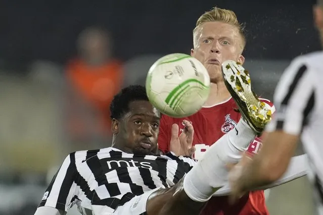 Partizan's Queensy Menig, left, duels for the ball with Cologne's Kristian Pedersen during the Europa Conference League, Group D soccer match between Partizan and FC Cologne, at the Partizan stadium in Belgrade, Serbia, Thursday, October 13, 2022. (Photo by Darko Vojinovic/AP Photo)