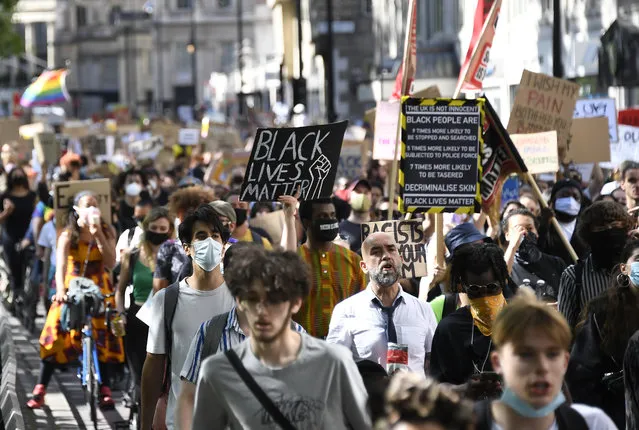 People, most wearing protective masks against the spread of coronavirus, march to Britain's Parliament in central London, Saturday, June 20, 2020, during a protest organised by Black Lives Matter, in the wake of the killing of George Floyd by police officers in Minneapolis, USA last month that has led to anti-racism protests in many countries calling for an end to racial injustice. Anti-racism demonstrators are holding a fourth weekend of protests across the U.K. (Photo by Alberto Pezzali/AP Photo)