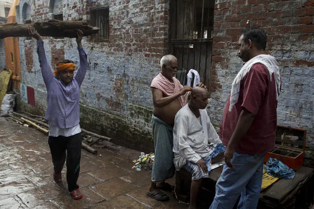 In this Friday, August 26, 2016 photo, a Hindu mourner has his head shaved after attending a funeral service in Varanasi, India. (Photo by Tsering Topgyal/AP Photo)