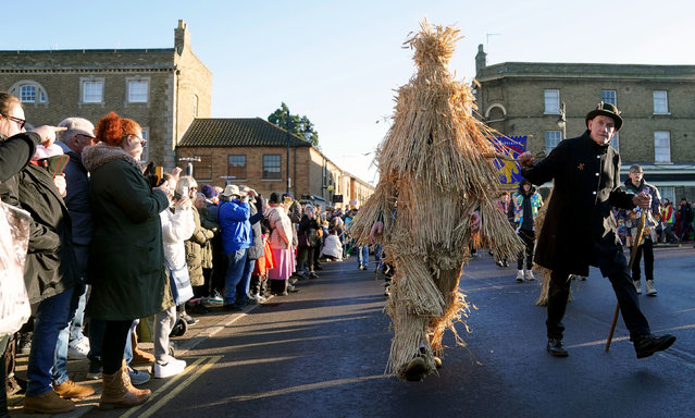 The Straw Bear is paraded through the streets accompanied by attendant keepers, musicians and dancers during the Whittlesea Straw Bear Festival in Whittlesea, Cambridgeshire, UK on Saturday, January 13, 2024. (Photo by Joe Giddens/PA Images via Getty Images)