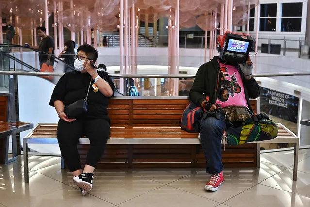 A man wears a Street Fighter console on his head during the first day of Thailand Comic Con 2022 in Bangkok on October 28, 2022. The leading comic collectibles exhibition in Thailand is back from 28 to 30 October, 2022. (Photo by Lillian Suwanrumpha/AFP Photo)