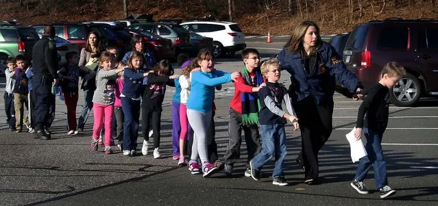 Connecticut State Police lead a line of children from the Sandy Hook Elementary School after the shooting at the school. (Photo by Shannon Hicks/Newtown Bee)