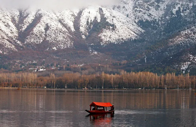 A man rows his boat in the waters of the Dal lake in Srinagar December 12, 2017. (Photo by Danish Ismail/Reuters)