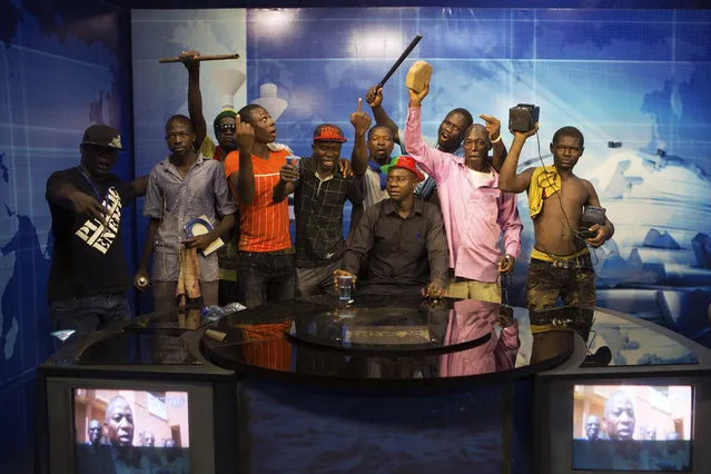 Anti-government protesters take over the state TV podium in Ouagadougou, capital of Burkina Faso, October 30, 2014. (Photo by Joe Penney/Reuters)