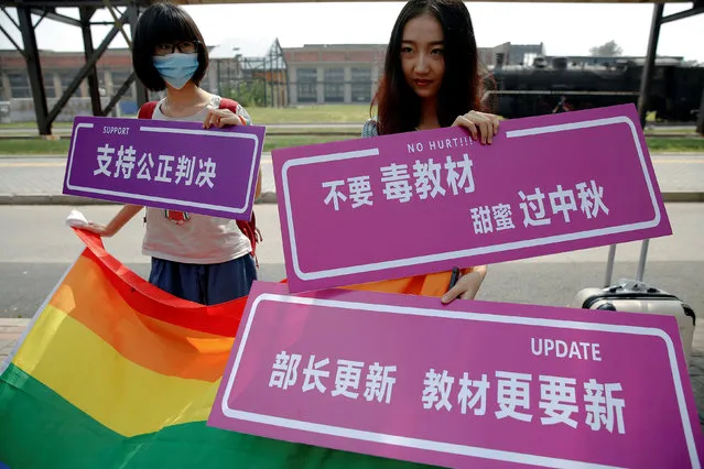 Supporters hold a rainbow flag and signs near the courthouse before the hearing in which a Chinese student lodged a suit against the Ministry of Education over school textbooks describing homosexuality as a mental disorder, in Beijing, China September 12, 2016. (Photo by Damir Sagolj/Reuters)
