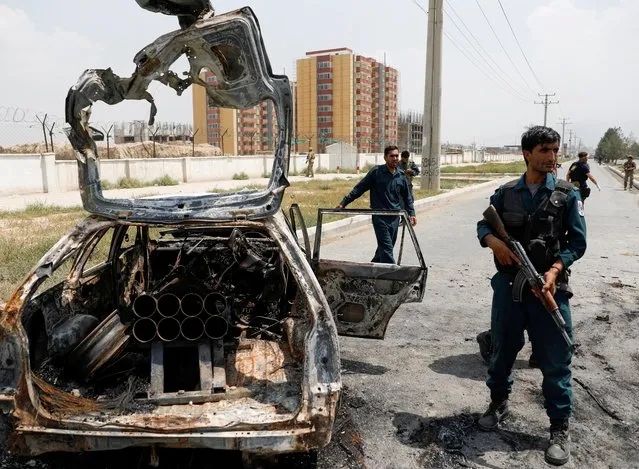 Afghan police officers inspect a vehicle from which insurgents fired rockets, in Kabul, Afghanistan on August 18, 2020. (Photo by Mohammad Ismail/Reuters)