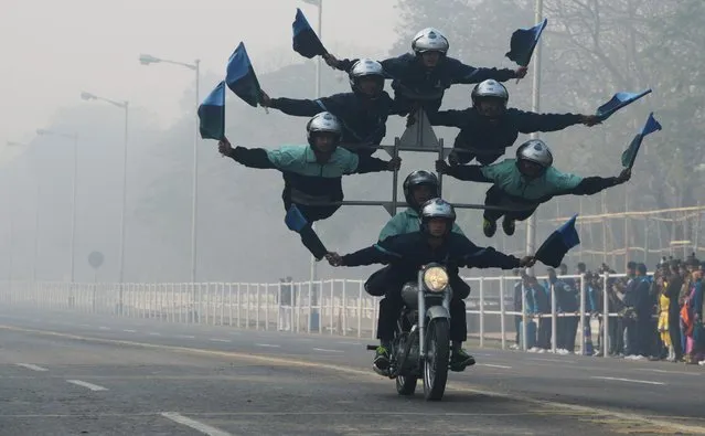 Indian army personel perform acrobatics on their bikes as they take part in a rehearsal ahead of the forthcoming Republic Day parade  in Kolkata on January 21, 2018. India will celebrate its 69th Republic Day on January 26. (Photo by Dibyangshu Sarkar/AFP Photo)
