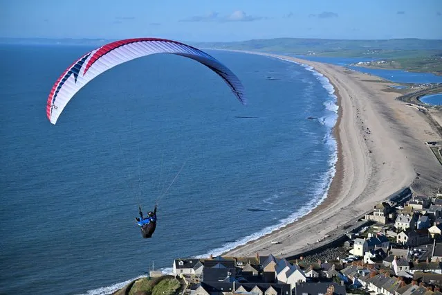 A paraglider takes off over Chesil beach, on January 02, 2023 in Portland, United Kingdom. (Photo by Finnbarr Webster/Getty Images)