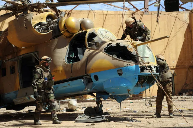 French army deminers secure a helicopter in a hangar at the Gao airport, on February 9, 2013. Two Malian soldiers and four civilians have already been killed by landmines, and French troops are still fighting off what Paris called “residual jihadists” in reclaimed territory. (Photo by Pascal Guyot/AFP Photo/The Atlantic)