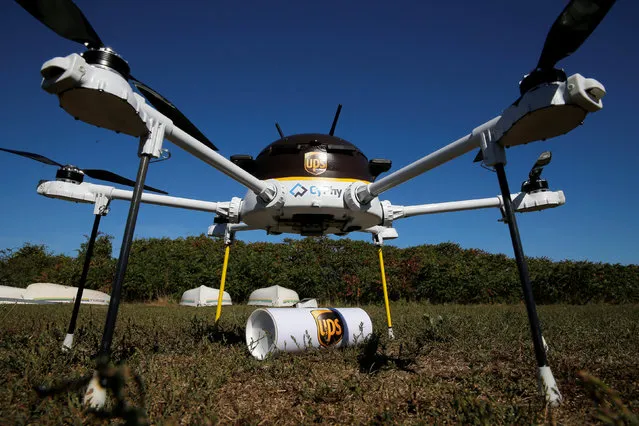 A drone, made by CyPhy Works, stands over the UPS package it carried to Children's Island off the coast of Beverly, Massachusetts, U.S. September 22, 2016, during UPS's demonstration of a drone making a commercial delivery of a package to a remote or difficult-to-access location. (Photo by Brian Snyder/Reuters)