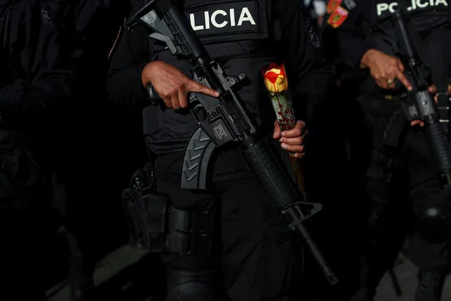 A female police officer of the new Specialized Police Tactical Unit (UTEP) known as “Jaguares” of El Salvador National Civil Police, holds a rose for Valentine's day during their presentation ceremony in San Salvador, El Salvador February 14, 2018. (Photo by Jose Cabezas/Reuters)