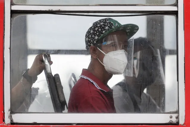 People wearing face mask and face shields to help curb the spread of COVID-19 ride a bus in Quezon city, Philippines on Wednesday, August 19, 2020. Philippine President Rodrigo Duterte has decided to ease a mild coronavirus lockdown in the capital and four outlying provinces to further reopen the country's battered economy despite having the most reported infections in Southeast Asia. (Photo by Aaron Favila/AP Photo)