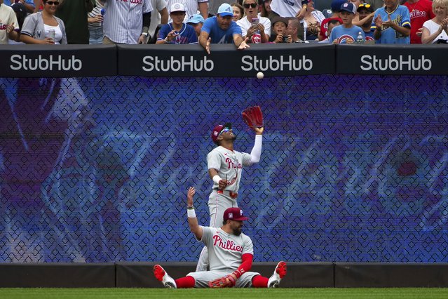 Philadelphia Phillies outfielder Kyle Schwarber (12) throws up his caught ball during the first inning of a baseball game against the New York Yankees, Sunday, July 27, 2025, in New York. (Photo by Angelina Katsanis/AP Photo)