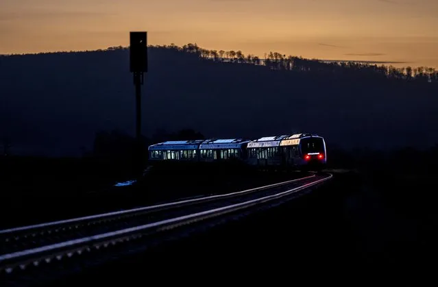 A hydrogen train drives through the Taunus region near Frankfurt, Germany, early Tuesday, January 31, 2023. The new trains of the Taunusbahn will replace the Diesel trains on this route. (Photo by Michael Probst/AP Photo)